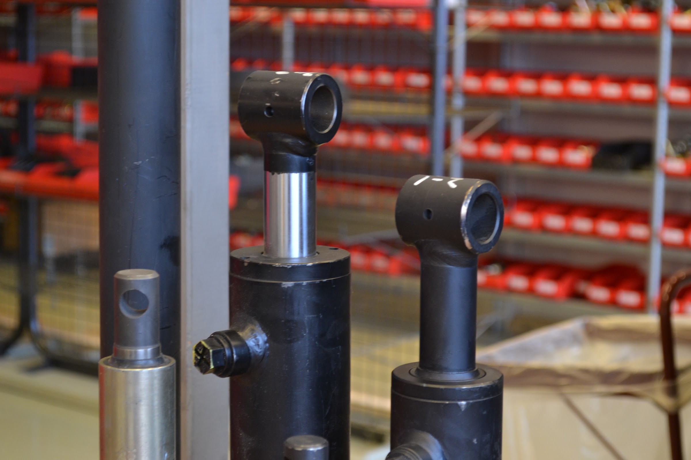 Hydraulikksylindre foran hyller med røde bokser